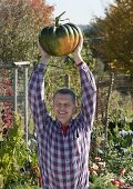 Man with pumpkin 'Muscat de Provence' (Cucurbita)