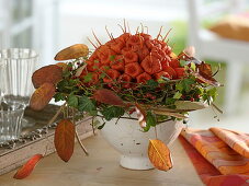 Lampion bouquet in wreath of ivy, clematis and rosehips