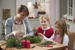 Mother with daughters making Advent wreath