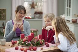 Mother with daughters making Advent wreath