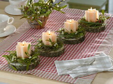 Schlichter Adventskranz aus einzelnen Stern-Kerzen auf Baumscheiben