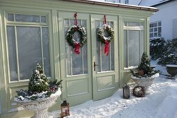 Snowy garden house decorated for Christmas with wreaths