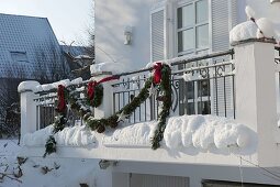 Decorating a balcony with garland for Christmas 2/3