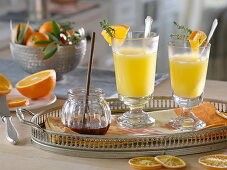 Hot orange juice in grog glasses, pieces of orange