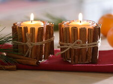 Candles in glasses covered with cinnamon sticks