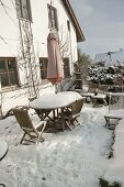 Snowy terrace at the house with wooden seating area