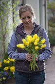 Frau mit gelbem Tulpenstrauß