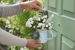 Blooming bellflower in enameled milk pot as a welcome greeting