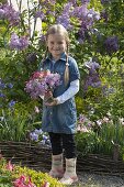 Girl with bouquet of Aquilegia (columbine) and Syringa (lilac)