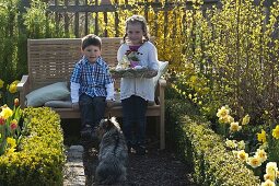 Kinder mit Osternest im Bauerngarten