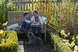 Kinder mit Osternest im Bauerngarten