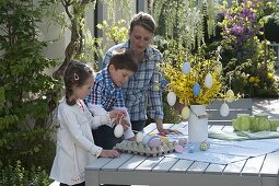 Woman with children decorating Easter bouquet