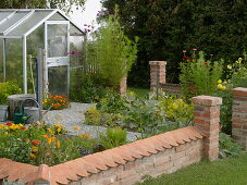 Kleiner Bauerngarten mit Mauer und Gewächshaus