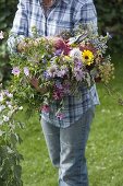 Woman with freshly cut bouquet from a cottage garden