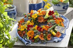Colorful vegetable wreath with herbs and edible flowers