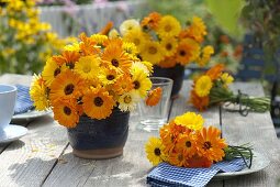 Sträuße aus Calendula (Ringelblumen) in blauen Töpfen