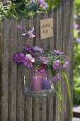 Glass lantern in wire basket with wreath of grasses and cosmos