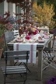 Herbstliche Rosen-Tischdeko auf der Terrasse