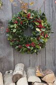 Simple wreath of Ilex (holly) over stack of firewood