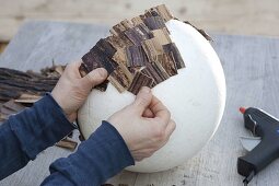 Sticking banana leaves on a polystyrene bowl (4/6)