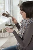 Woman smokes herbs in herbal bowl