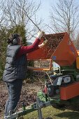 Woman chopping back woody plants with large shredder