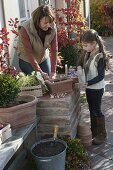 Mother and daughter planting spring box in autumn