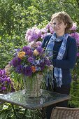 Woman sticks bouquet of Allium 'Globemaster', pink (roses)