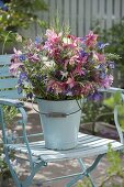 Bouquet of aquilegia (columbine) and grasses in enameled bucket