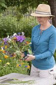 Woman tying a colourful bouquet of summer flowers