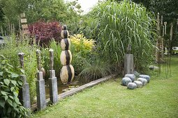 Garten mit getöpferten Kunstobjekten und Wasserspiel