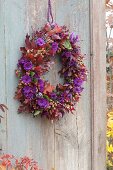Autumn wreath with violet cushions and red foliage