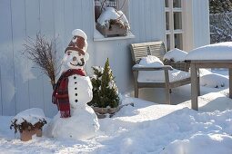 Schneemann mit Tontopf als Hut, Schal, Kohlstrunk als Pfeife, Karotte als Nase