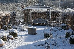 Verschneiter Rosengarten, Holz-Pavillon mit Bank, eingefaßt mit Hecke