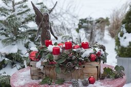 Spankorb mit Gaultheria (Scheinbeeren) als Adventskranz mit roten Kerzen