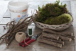 Yoghurt bucket covered with hazel twigs as a planter