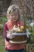 Girl with self-made Easter basket with hare's head as Easter nest