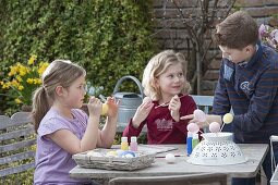 Children making and painting Easter eggs