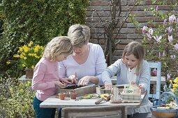 Mother and girl sowing sunflowers