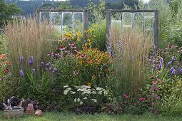 Perennial bed with old windows as decorative objects