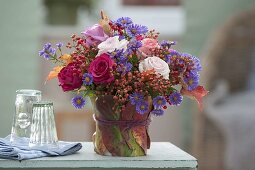 Autumn bouquet of pink (roses, rosehips) and aster (autumn asters)