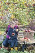 Frau mit Kindern bei der Apfelernte