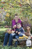 Frau mit Kindern bei der Apfelernte