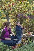 Woman with children harvesting apples