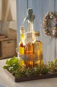 Bottles of herb vinegar and oil tied together on wooden coasters