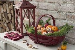 Red Santa Claus basket filled with oranges, mandarins, apples