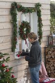 Decorate window with garland and wreath for Christmas