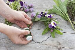 Tying a small wreath of herbs and edible flowers