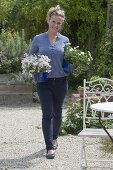 Woman placing white flowers in blue enamel pots