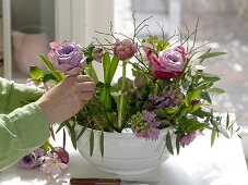 Violet-rosa Fruehlingsgesteck mit Steckhilfe in Suppenterrine